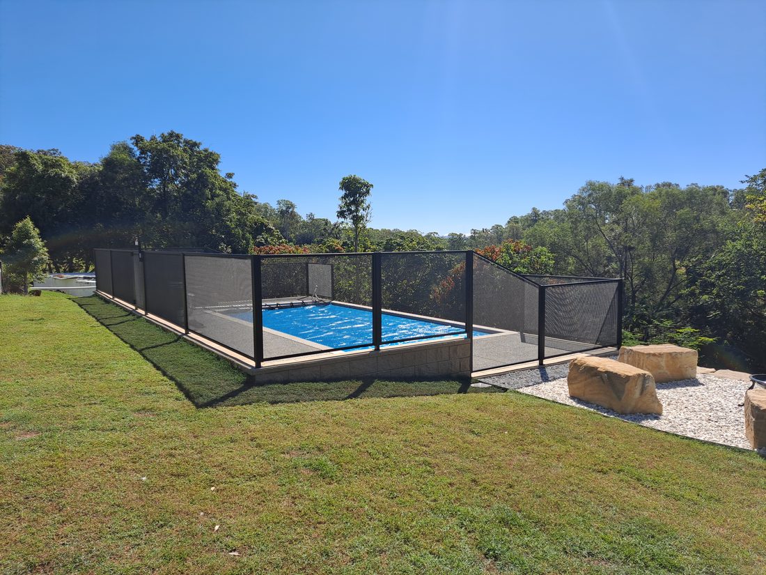 Pure Perf signature perforated pool fencing in Textured Black — the fence disappears into the view